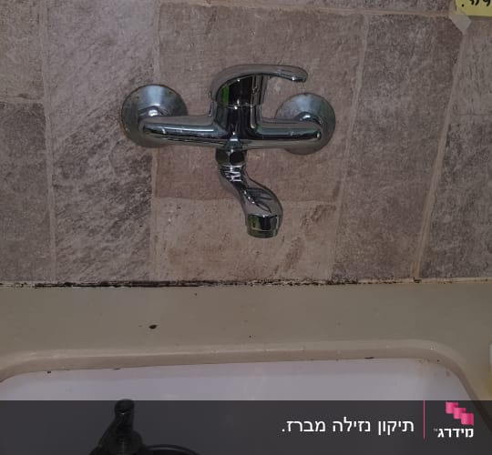 ברז מים מעל כיור במטבח